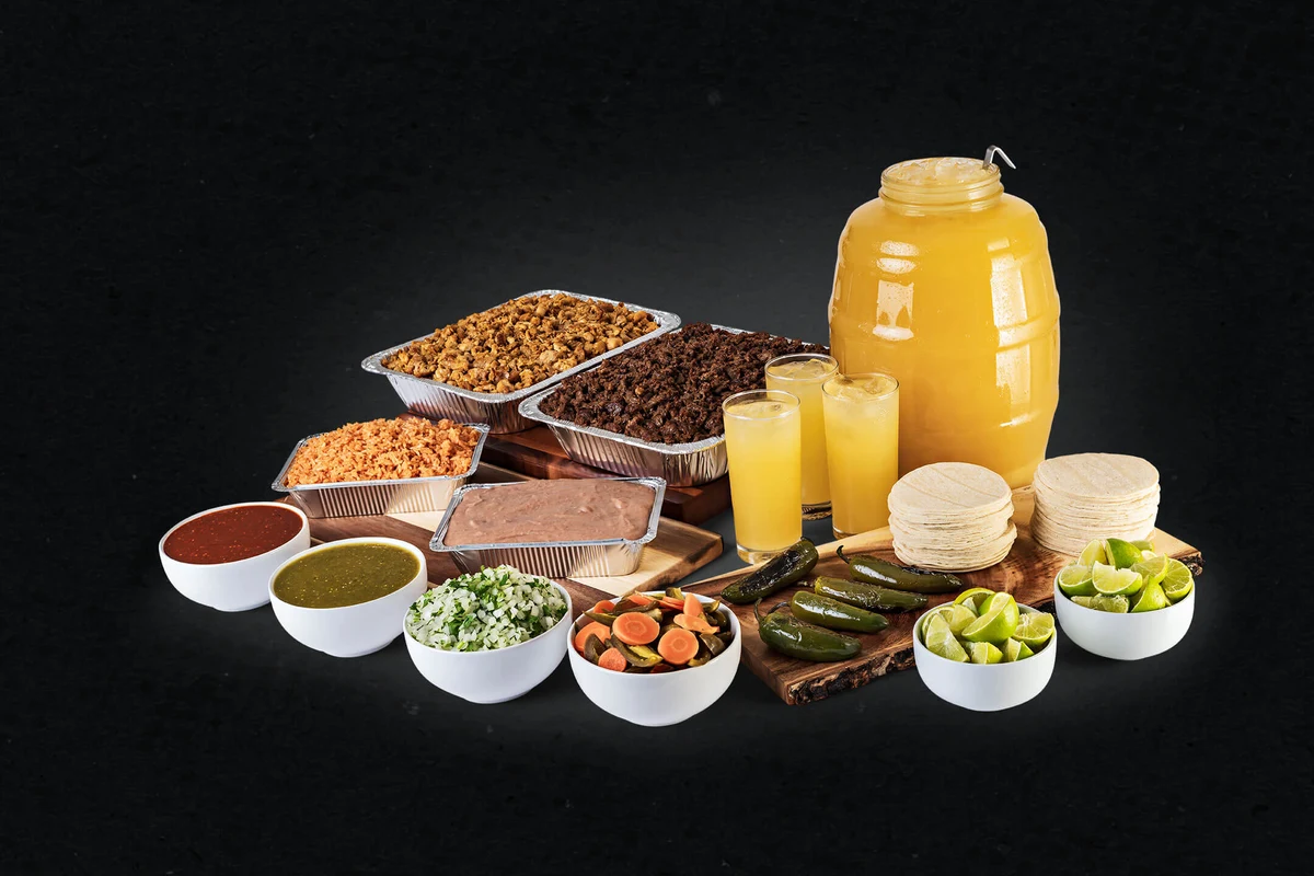 Fiesta Platter with assorted meats, salsas, tortillas, rice, beans, and aguas frescas